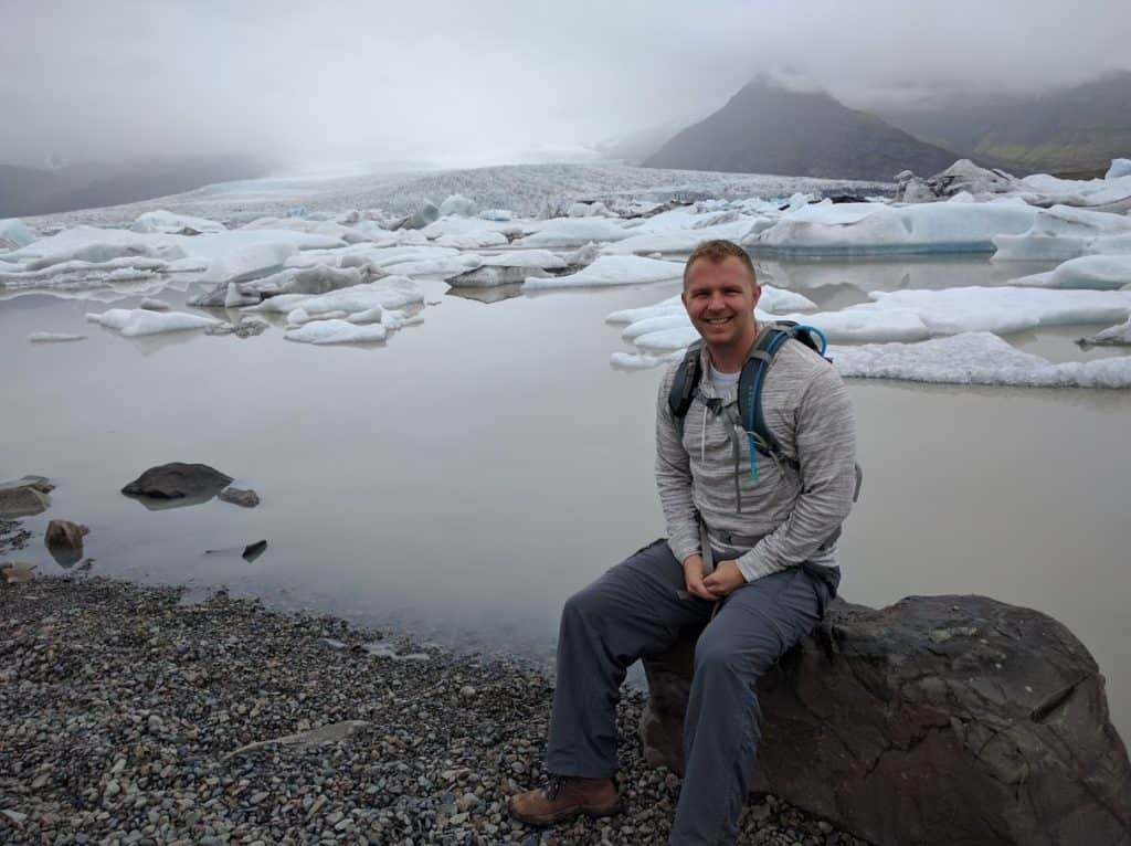 Me sitting next to Glacier Lagoon in Iceland with a glacier in the background