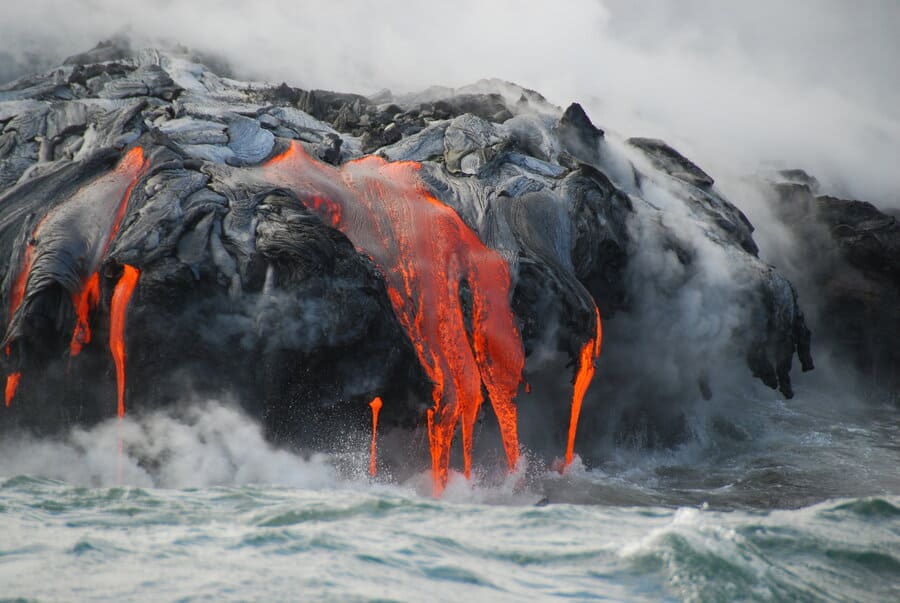 The famous lava of Kilauea spilling into the ocean, throwing up clouds of steam.