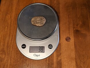 A skipping stone on a scale showing tha tit weights 38 grams