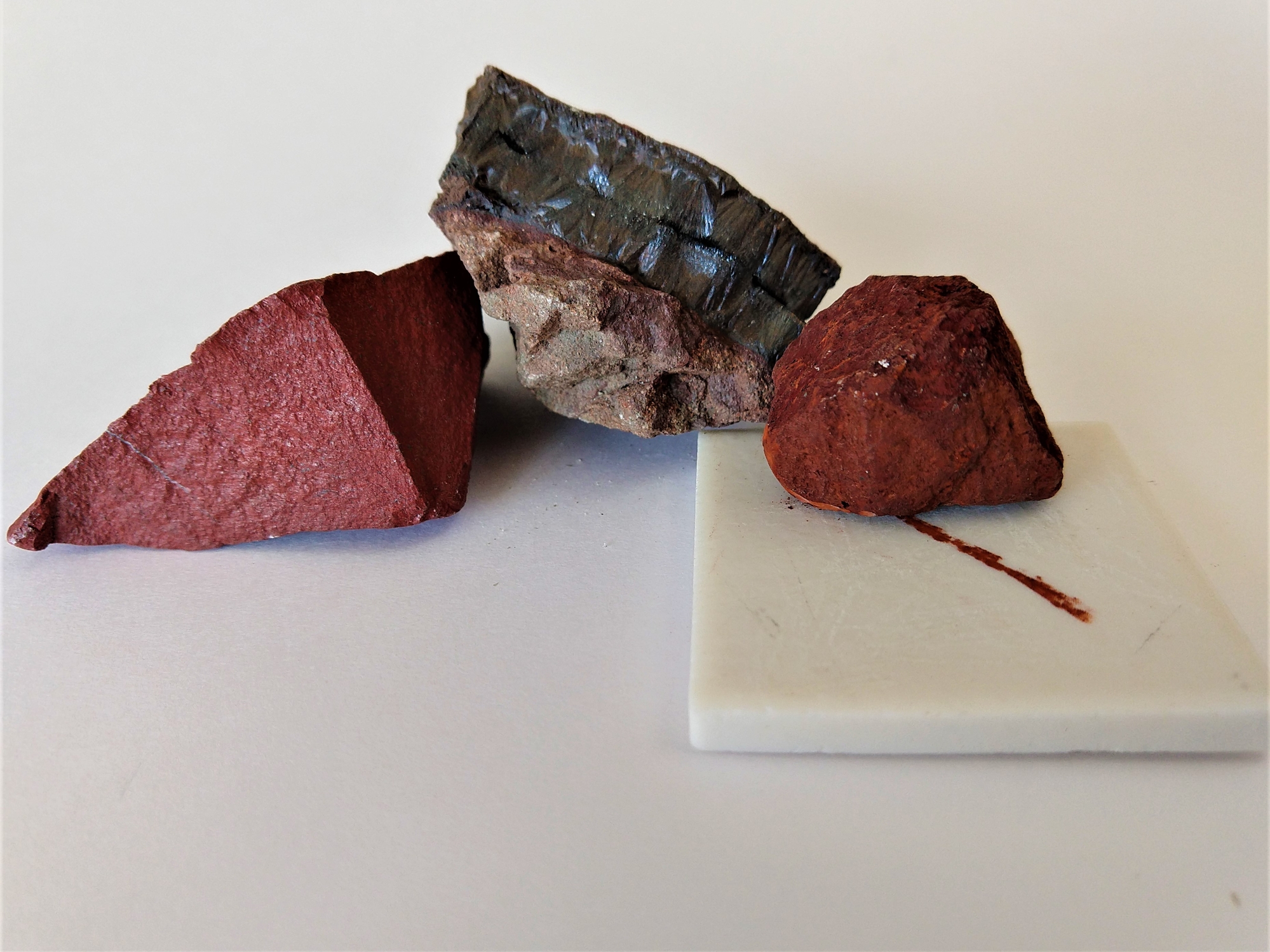 Hematite specimen with a rust-red streak on a ceramic plate